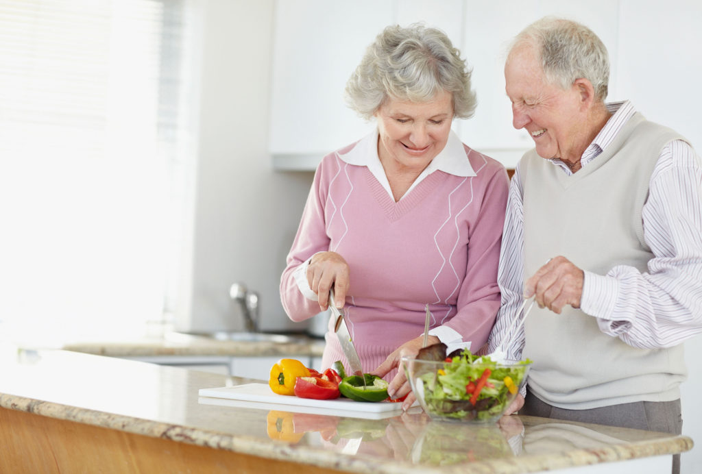 Senior couple preparing a healthy salad for lunch.