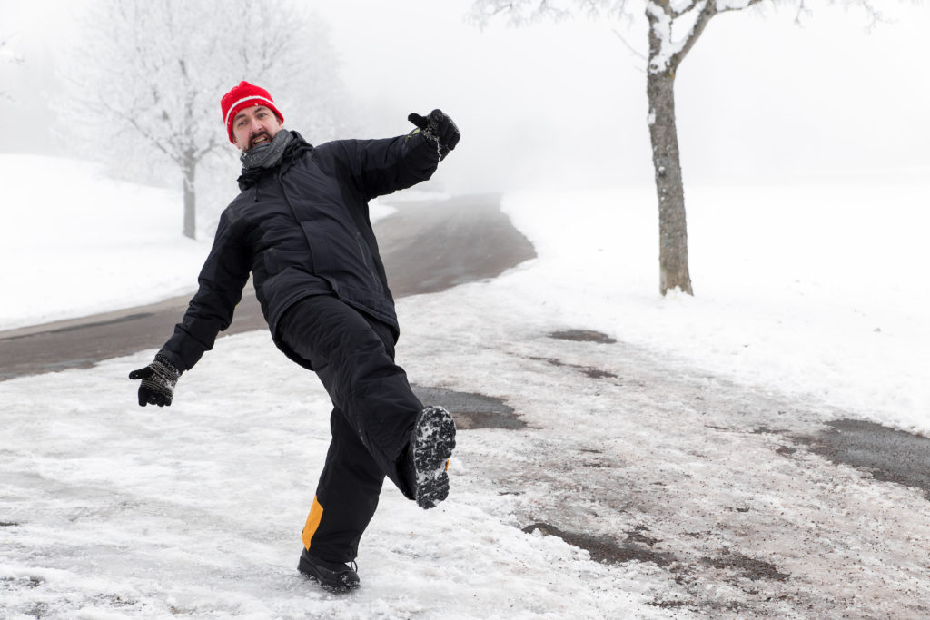 Man slips on icy walkway.