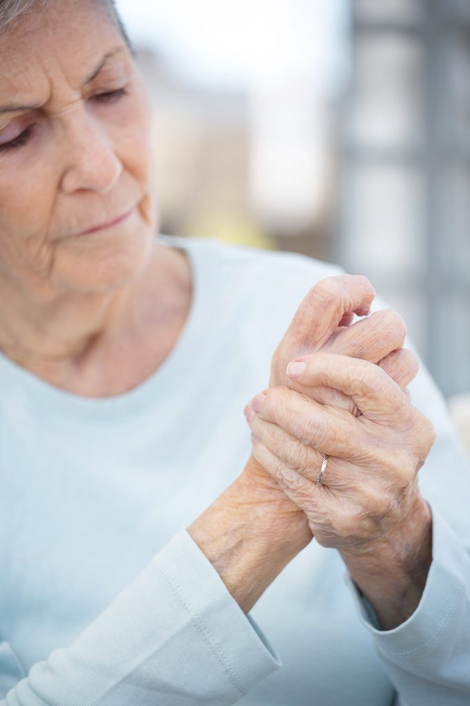 Senior woman massaging painful hand joints.