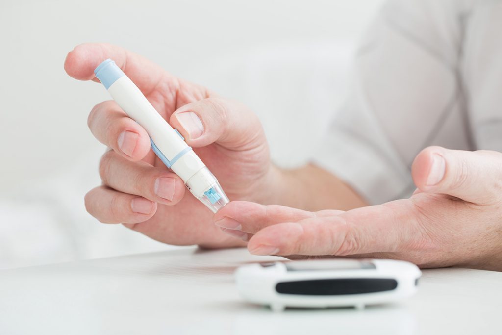 Diabetes patient measuring blood sugar with a glucometer.