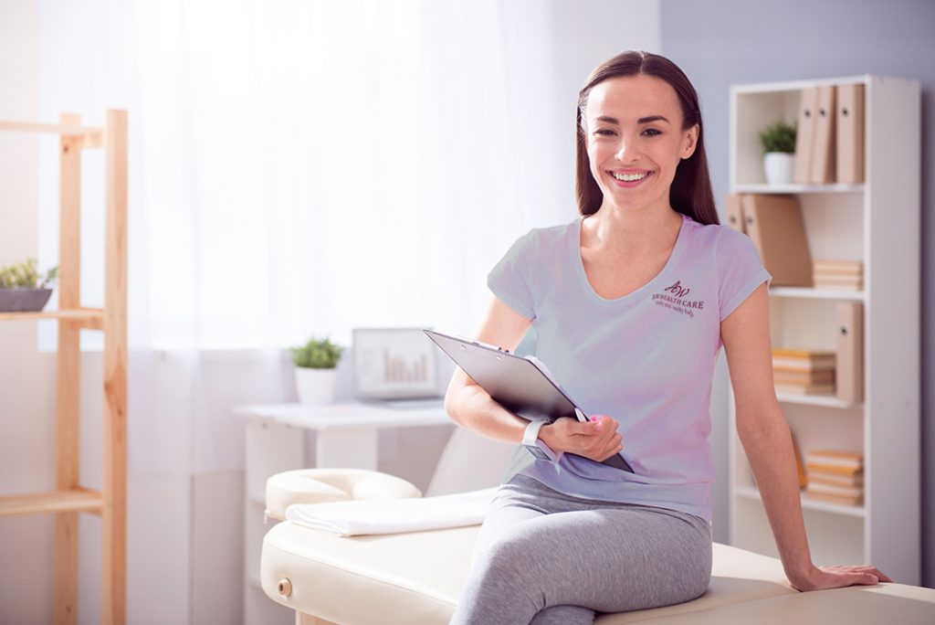 Young physician assistant faces camera with pretty smile. 