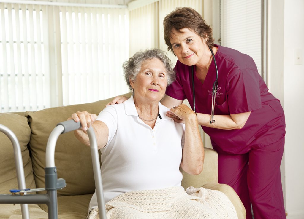 Nurse and patient smiling in a home setting.