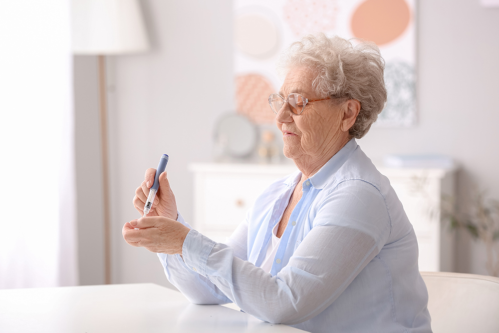 Diabetic senior woman measuring blood sugar level at home