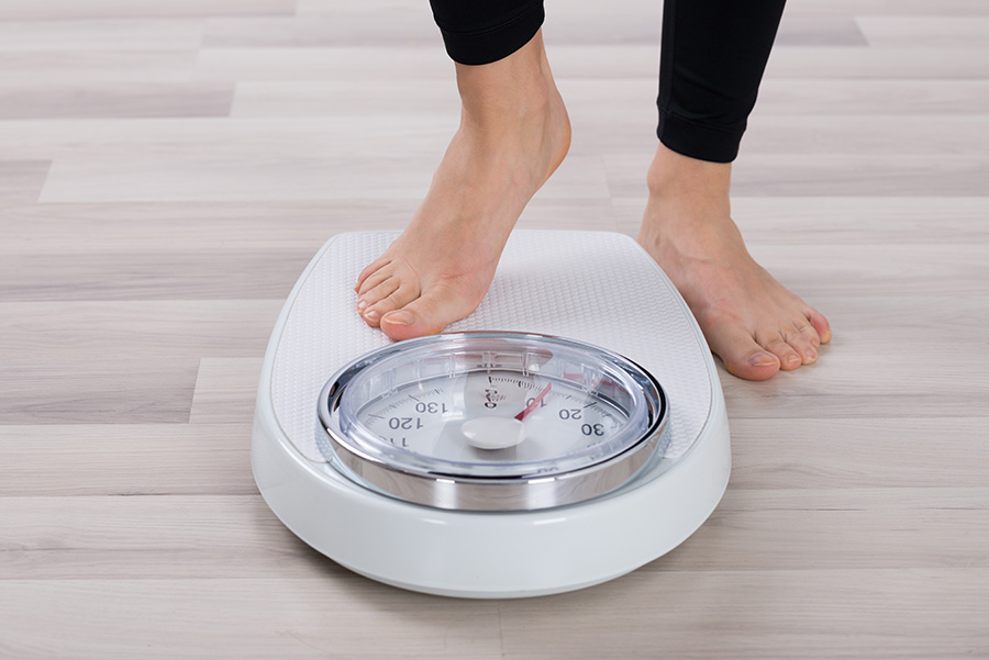 Woman's feet stepping onto the scale.