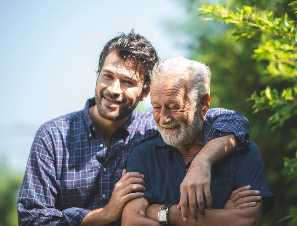 Father and son hugging in beautiful sunlight on an outdoor walk.