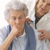 Elderly woman coughing during pulmonary exam with a pulmonologist.
