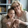 Grandmother teaches young granddaughter how to knit.